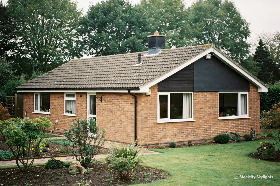 Detached brick bungalow with a timber-clad gable and a large front garden