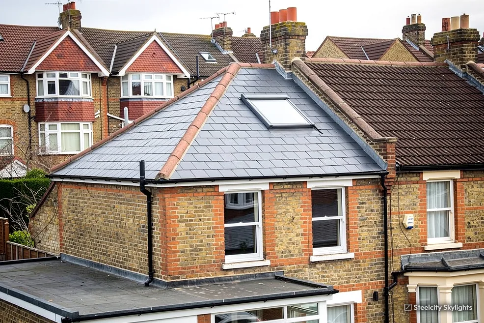 Slate roof with a roof window on the rear outshot of a brick terrace