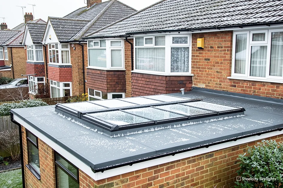 Multi-pane flat rooflight on the frosty flat roof of a brick extension, semis behind
