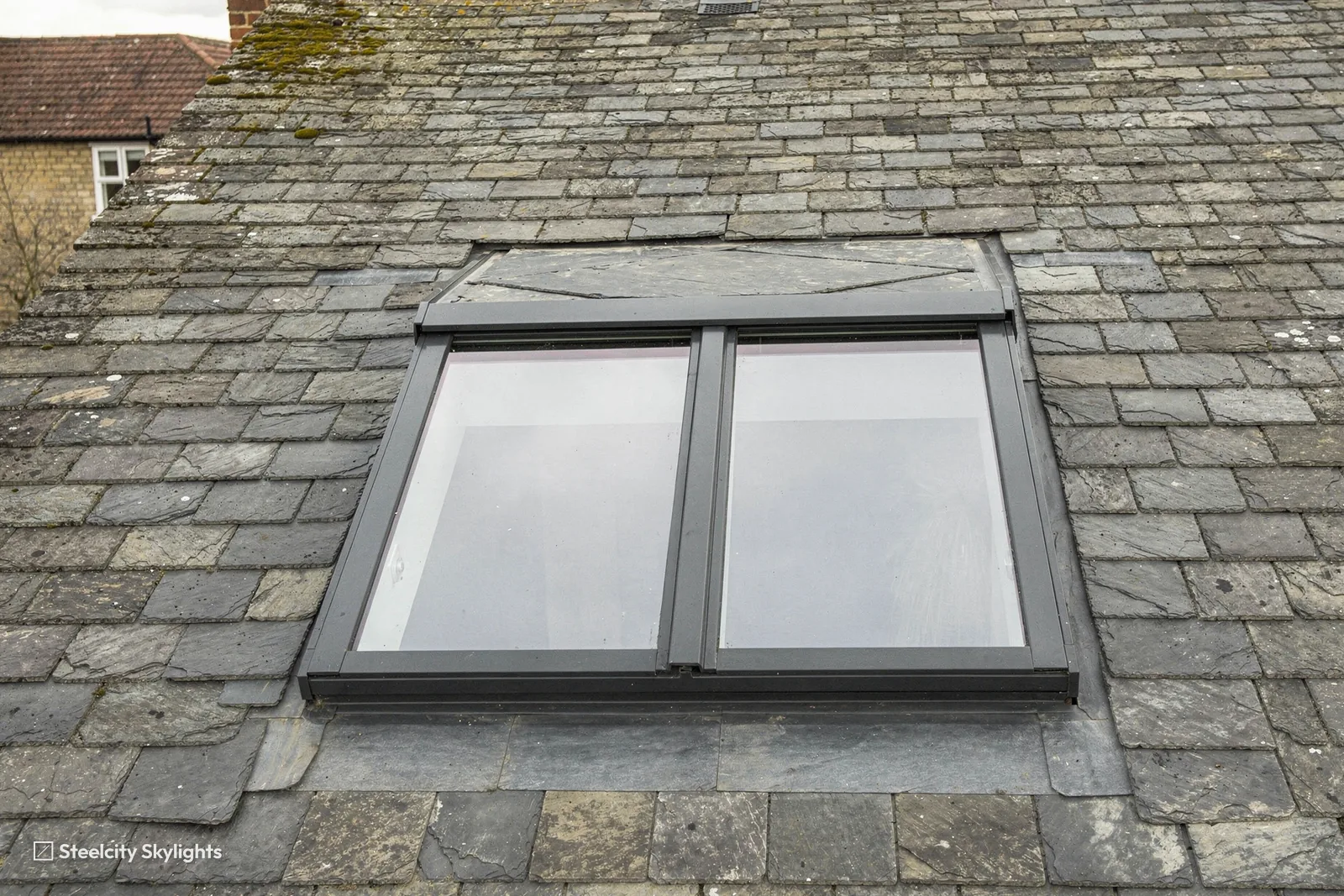 Close view of a two-pane conservation rooflight in an old slate roof