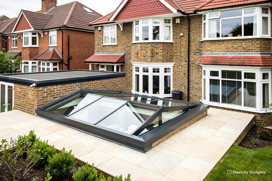 Hipped roof lantern set low within a paved patio behind brick semis