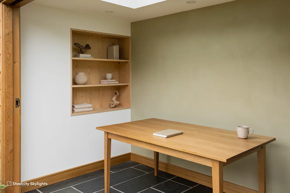 Garden studio with an oak desk, built-in shelves and a slate floor, lit from above