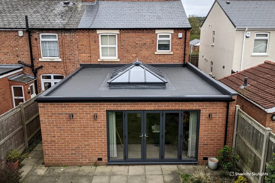 Brick rear extension with a hipped roof lantern and folding doors on a terraced house
