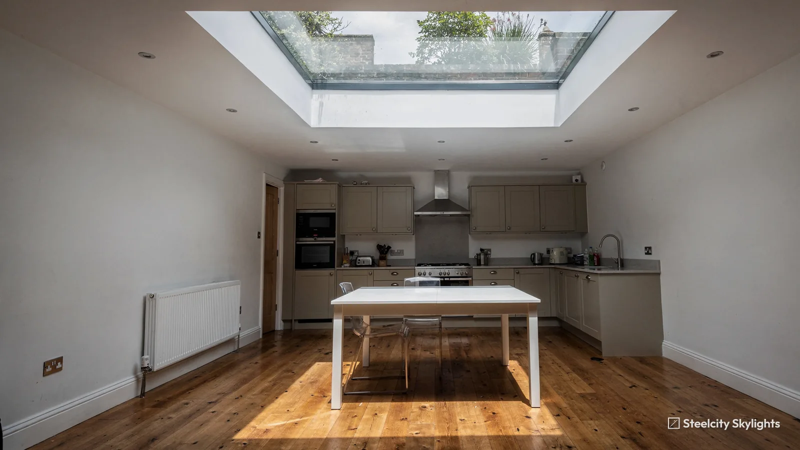 Lower ground floor kitchen lit by a walk-on glass rooflight set into the ceiling above the table
